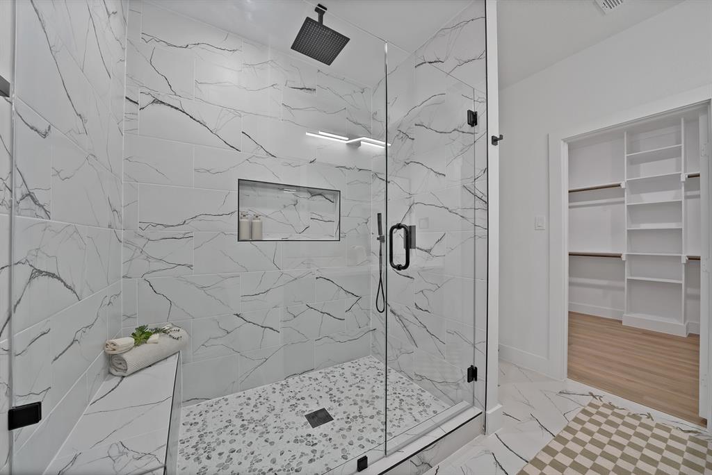 805 Tierney Road Fort Worth, TX 76112 - Photo 24 of 36 Walk-in shower with clear glass enclosure, rainfall showerhead, tiled bench, and recessed niche