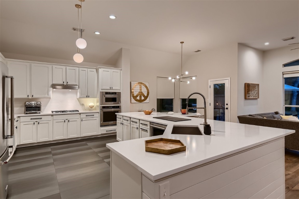 a kitchen with kitchen island a white counter top space and appliances