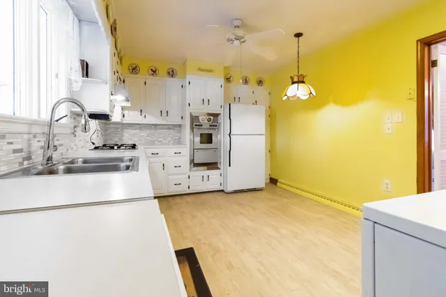 a kitchen with stainless steel appliances granite countertop a sink a stove and a refrigerator