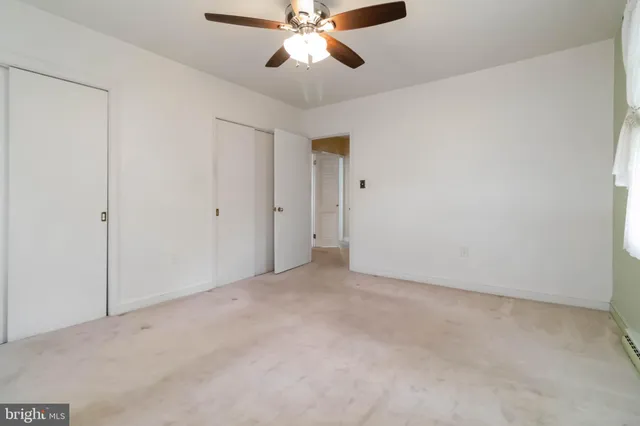 an empty room with chandelier fan