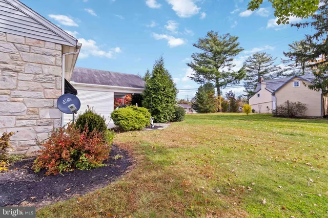 a front view of house with yard and trees in the background