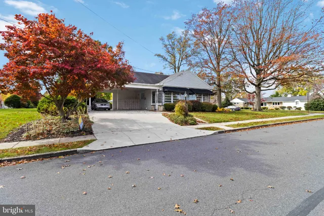 a view of a house with a yard and large tree