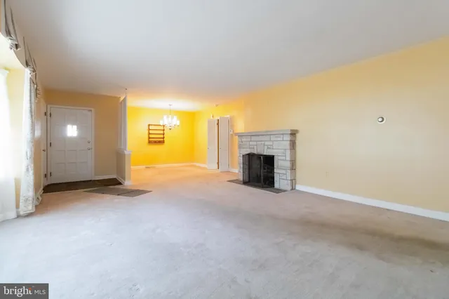 an empty room with a fireplace and fan