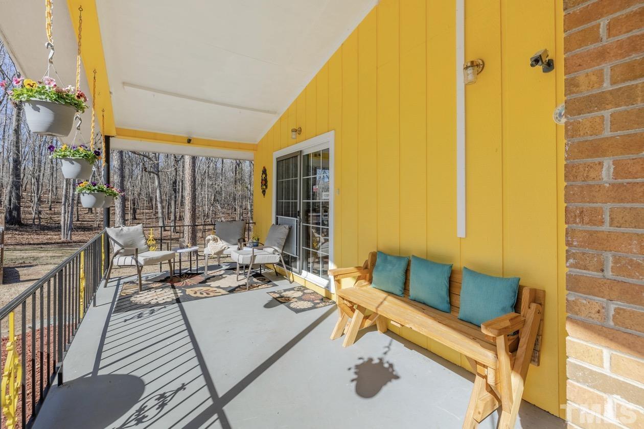 8200 McKee Road Rougemont, NC 27572 - Photo 9 of 32 a balcony with furniture and a potted plant