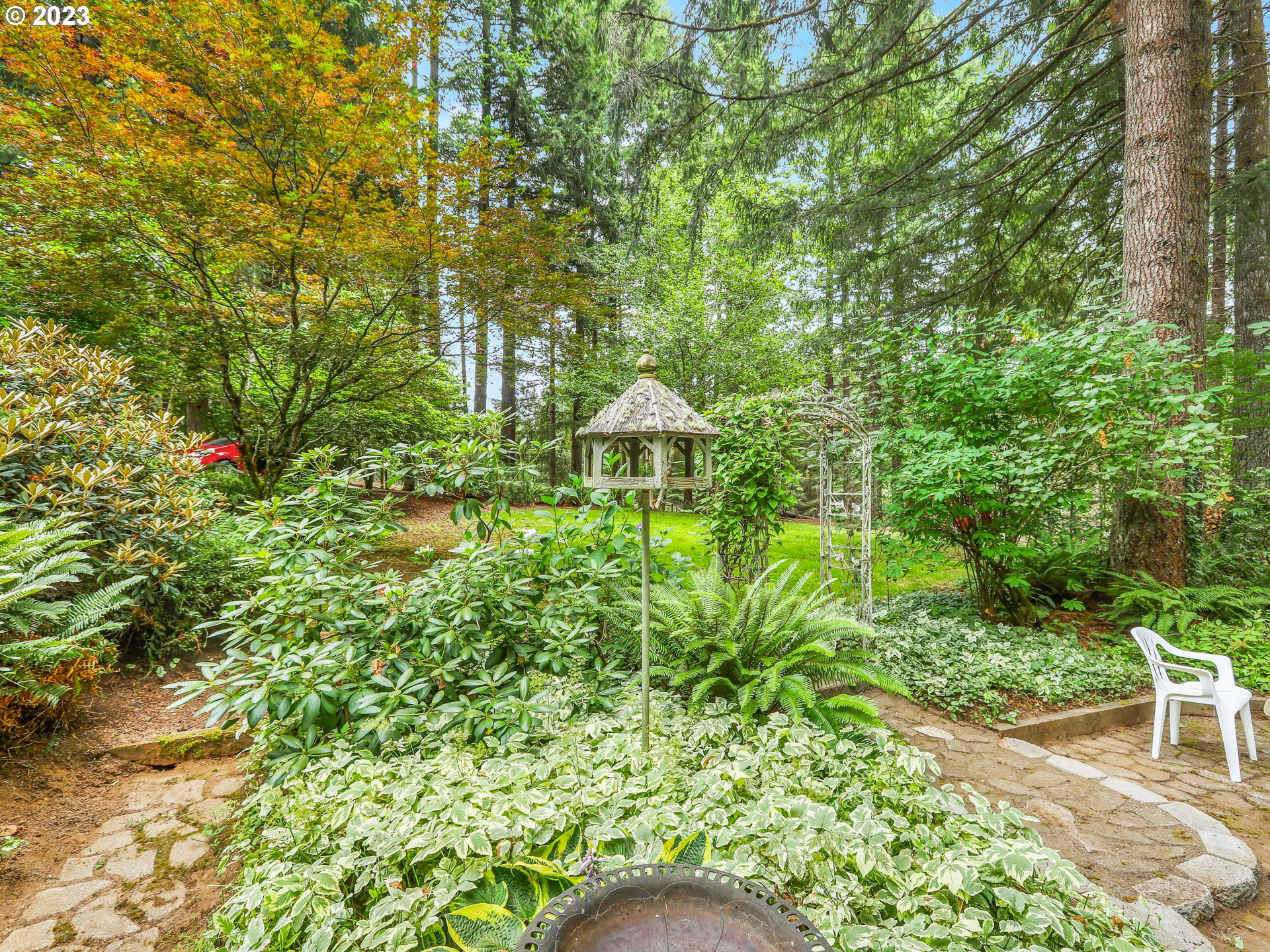 25875 South Morgan Road Estacada, OR 97023 - Photo 29 of 36 a backyard of a house with table and chairs under an umbrella