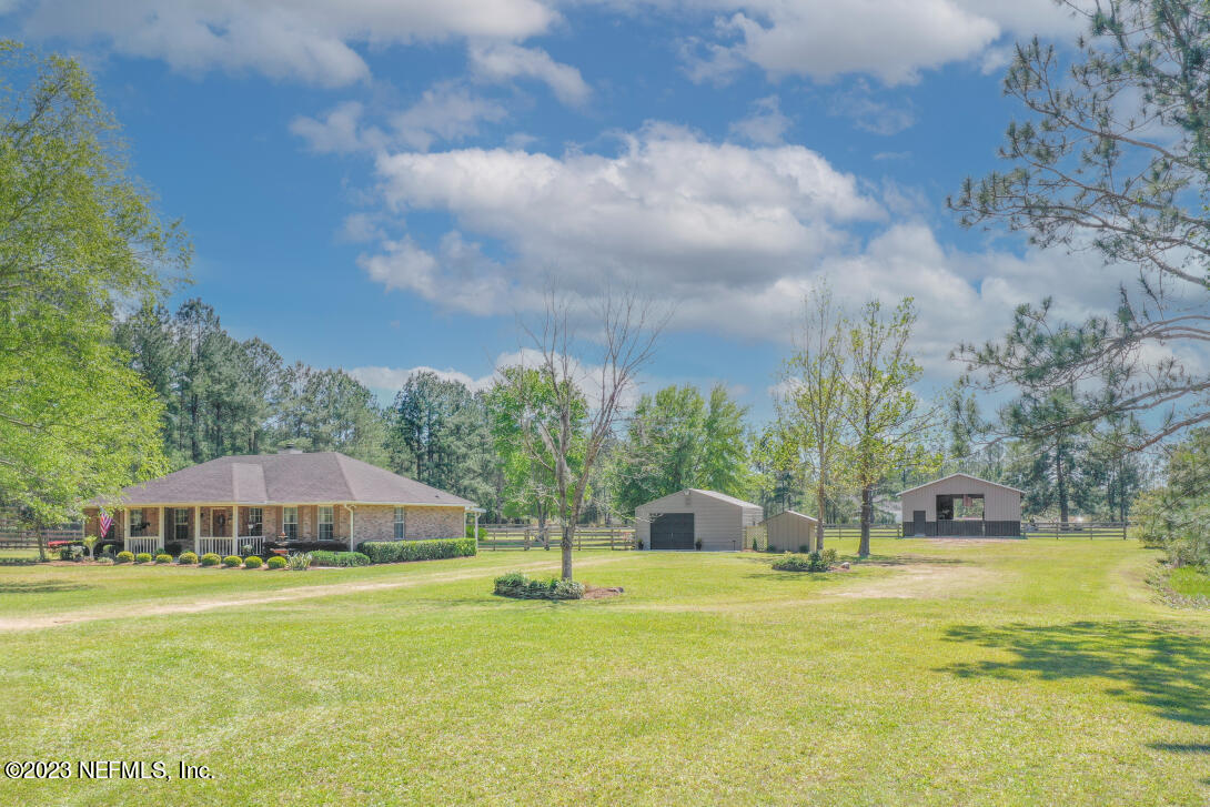 37491 Poole Road Hilliard, FL 32046 - Photo 14 of 39 a view of a swimming pool with lawn chairs under an umbrella