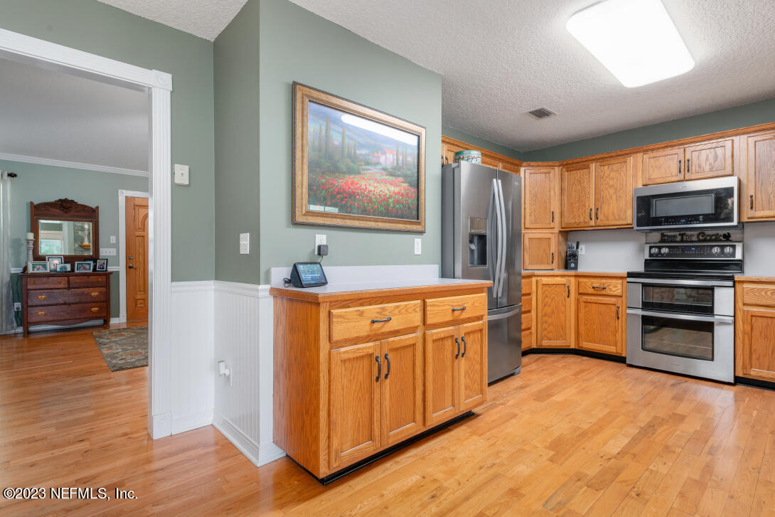 37491 Poole Road Hilliard, FL 32046 - Photo 21 of 39 a kitchen with stainless steel appliances a stove top oven and a refrigerator