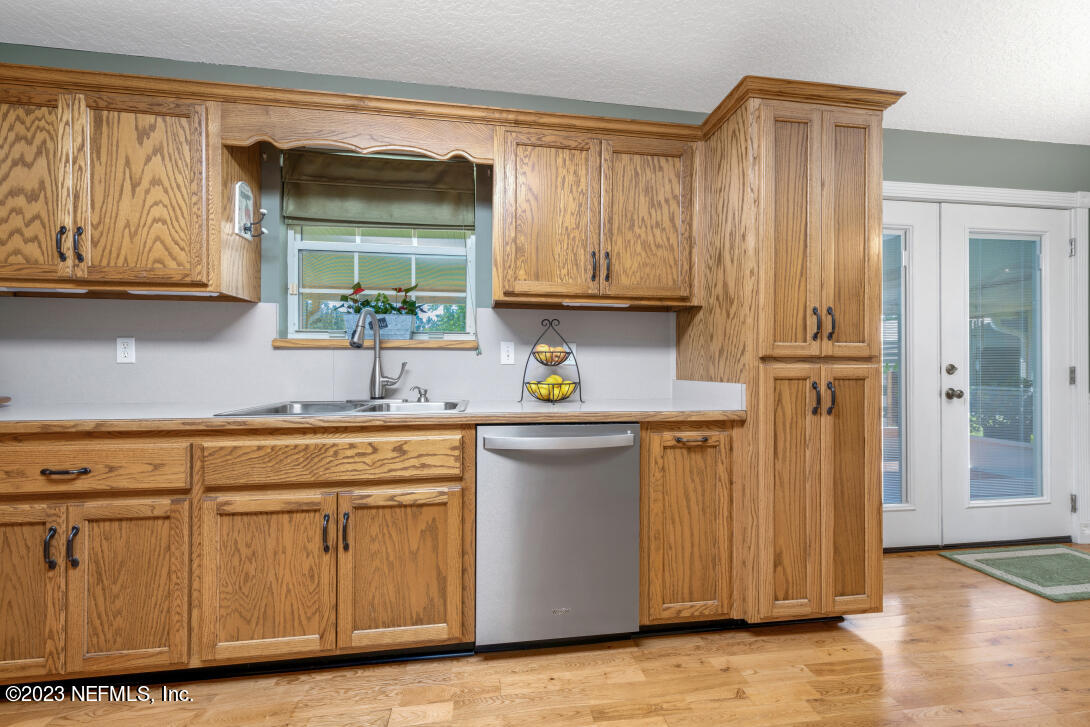 37491 Poole Road Hilliard, FL 32046 - Photo 23 of 39 a kitchen with stainless steel appliances granite countertop a sink and cabinets with wooden floor