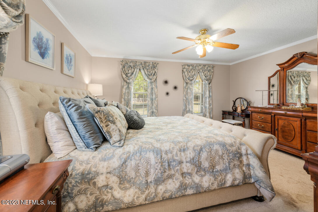 37491 Poole Road Hilliard, FL 32046 - Photo 26 of 39 a bedroom with a large bed and a chandelier