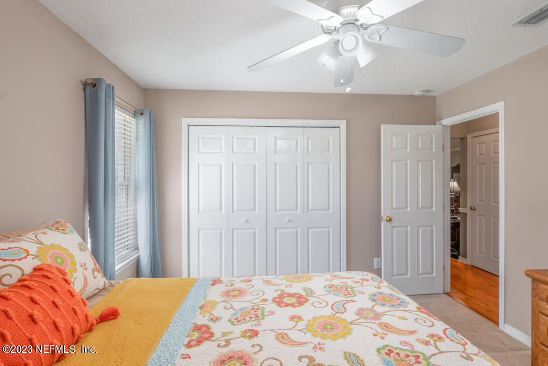 37491 Poole Road Hilliard, FL 32046 - Photo 32 of 39 a bedroom with a bed and a chandelier