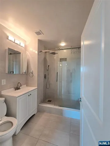 a bathroom with a double vanity sink toilet mirror and shower