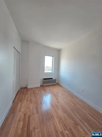 an empty room with wooden floor and window