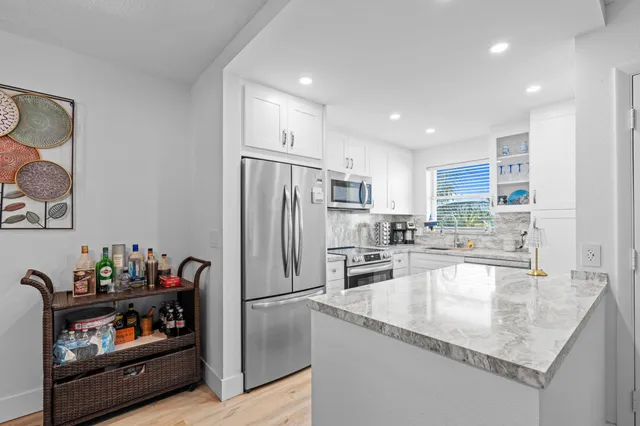 a kitchen with granite countertop a refrigerator and a sink