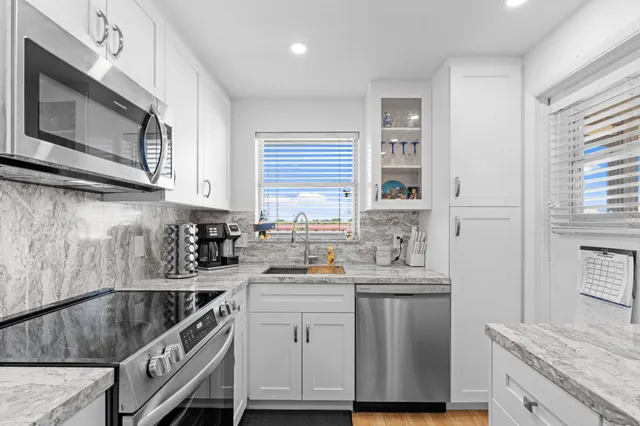 a kitchen with stainless steel appliances a sink stove and cabinets
