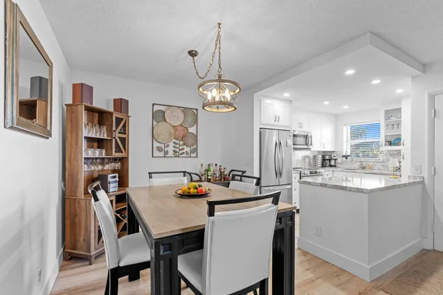 a dining room with stainless steel appliances a table and chairs