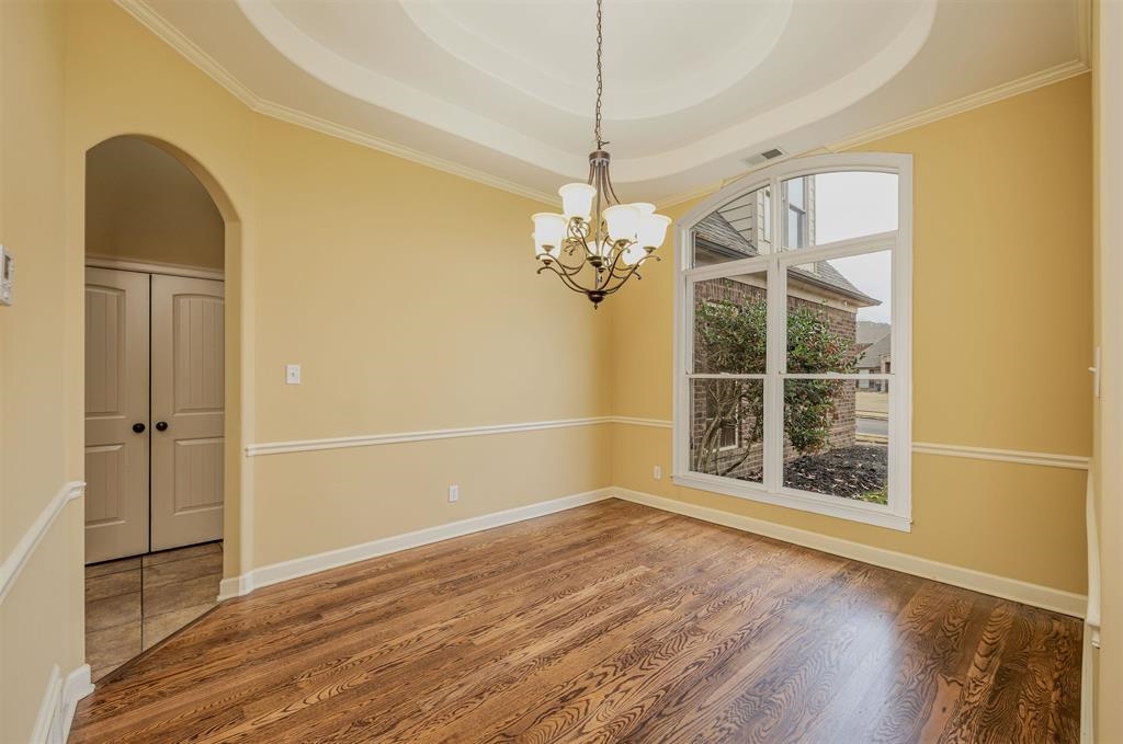 5380 Scarlet Ridge Drive Arlington, TN 38002 - Photo 6 of 35 Recessed tray ceiling with a chandelier, wood-finish flooring, and an arched window