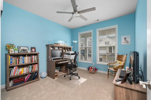 a view of a workspace with furniture and a bookshelf