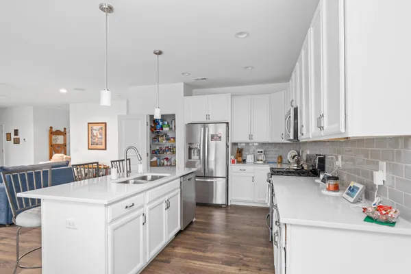 a kitchen with kitchen island a sink a stove and refrigerator