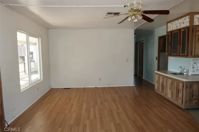 a view of room with hardwood floor and a ceiling fan