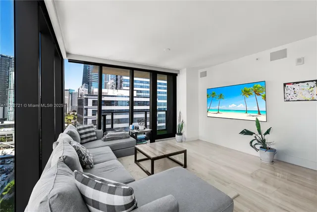 a living room with furniture and a floor to ceiling window