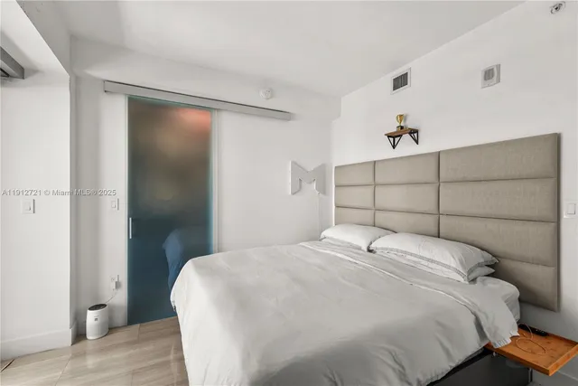 a bedroom with a bed and a painting on the wall