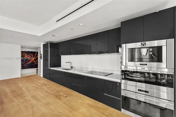 a kitchen with stainless steel appliances a stove microwave and sink