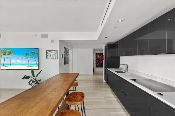 a living room with stainless steel appliances kitchen island granite countertop furniture and a wooden floor