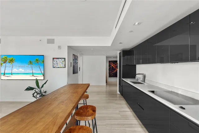 a living room with stainless steel appliances kitchen island granite countertop furniture and a wooden floor
