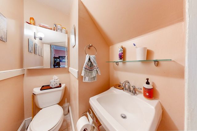 a bathroom with a toilet sink and mirror