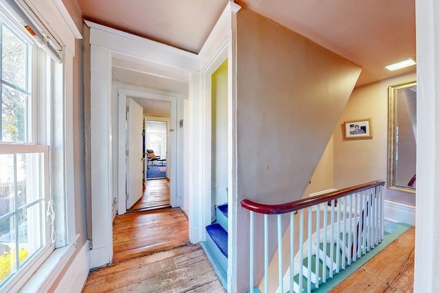 a view of a hallway with wooden floor and staircase
