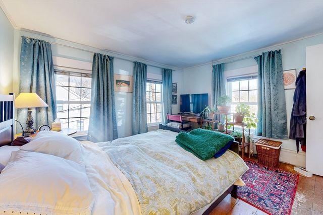 a bedroom with a bed flat screen tv and a large window