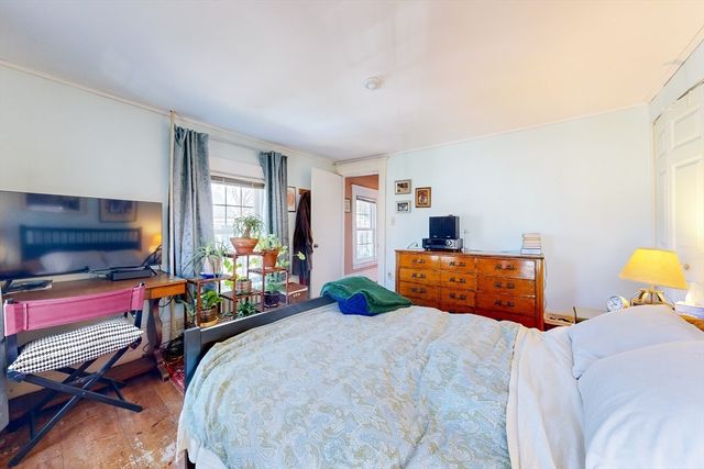 a bedroom with a bed and large windows