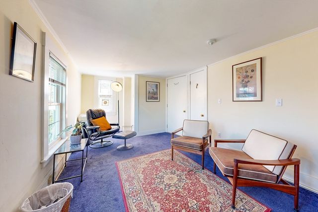 a living room with furniture a rug and a window