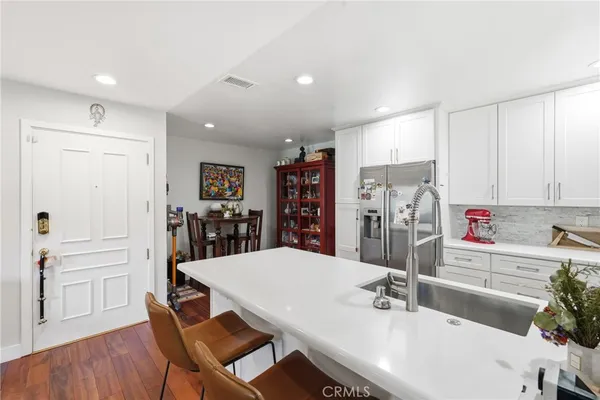 a kitchen with stainless steel appliances kitchen island granite countertop a refrigerator and microwave