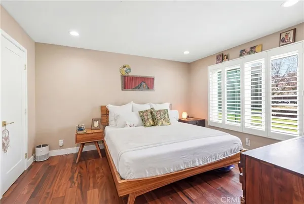 a bedroom with a bed and a dresser next to a window
