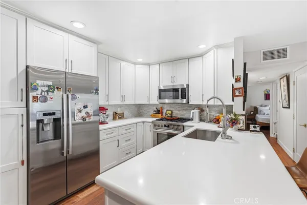 a kitchen with stainless steel appliances a refrigerator sink and cabinets