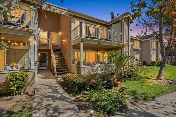 a front view of a multi story residential apartment building with yard and outdoor seating