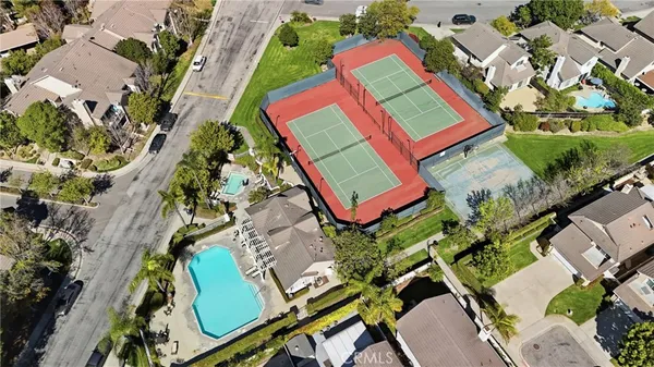 an aerial view of a tennis ground and a cars park