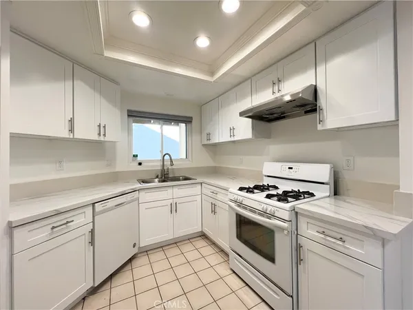 a kitchen with stainless steel appliances granite countertop a sink a stove and cabinets
