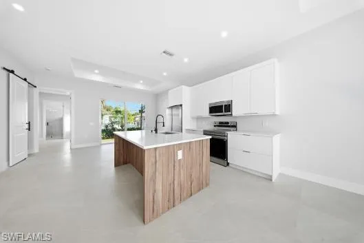 a view of a kitchen with a refrigerator and a sink