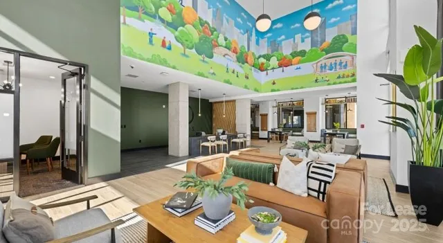 a view of a dining room with furniture one side kitchen view and wooden floor