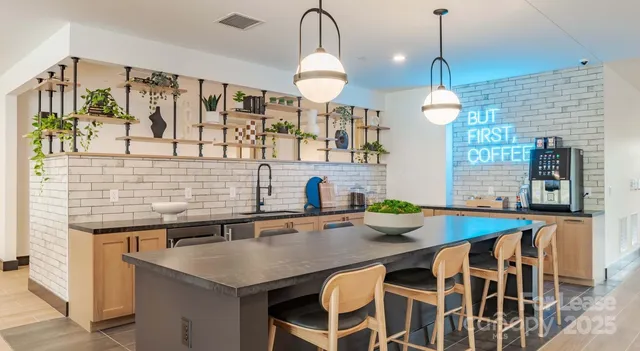 a kitchen with stainless steel appliances granite countertop a sink a stove and a wooden floors