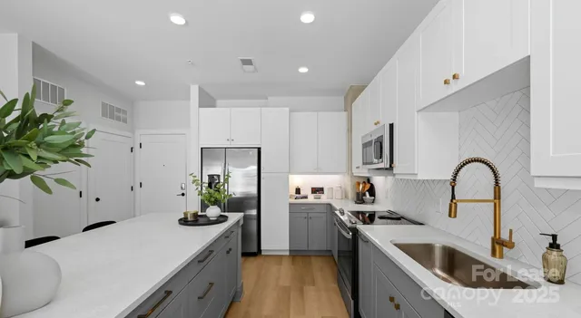 a kitchen with a sink stainless steel appliances and white cabinets