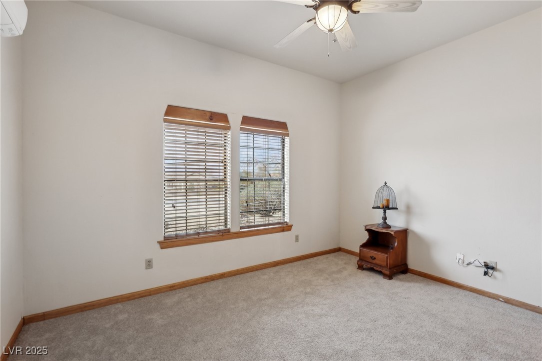 519 North Racetrack Road Henderson, NV 89015 - Photo 45 of 98 Carpeted empty room featuring a wall unit AC, ceiling fan, and baseboards