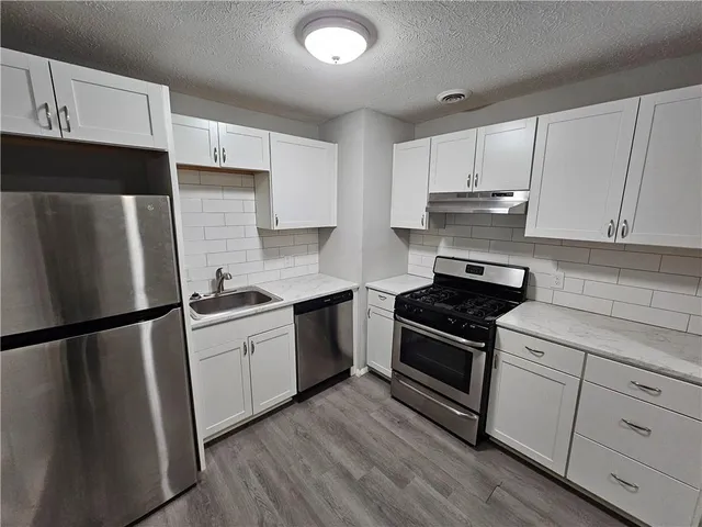 a kitchen with stainless steel appliances and wooden cabinets