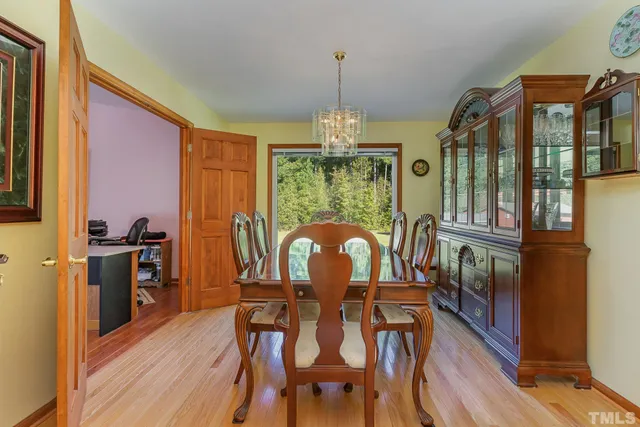a dining room with furniture a chandelier and wooden floor
