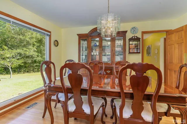a dining room with furniture a large window and wooden floor