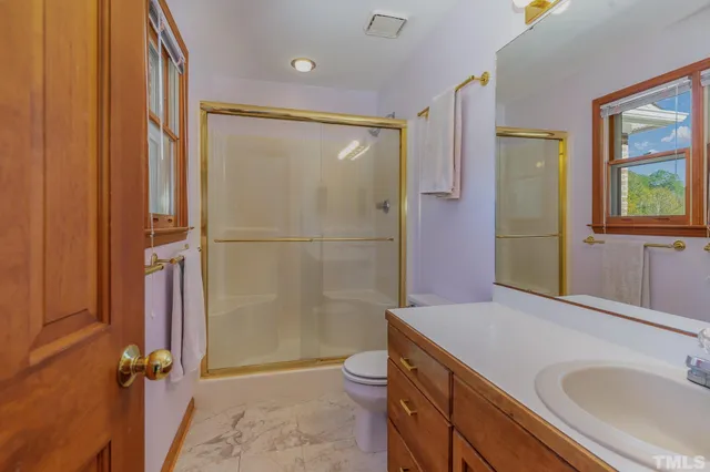 a bathroom with a granite countertop shower sink and mirror