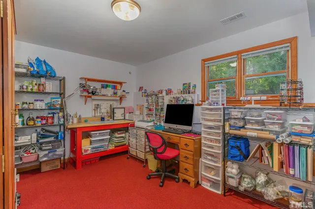 a bedroom with furniture a flat screen tv and a large window