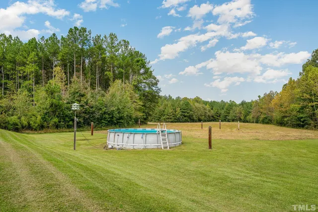 a view of a water with huge green field and trees